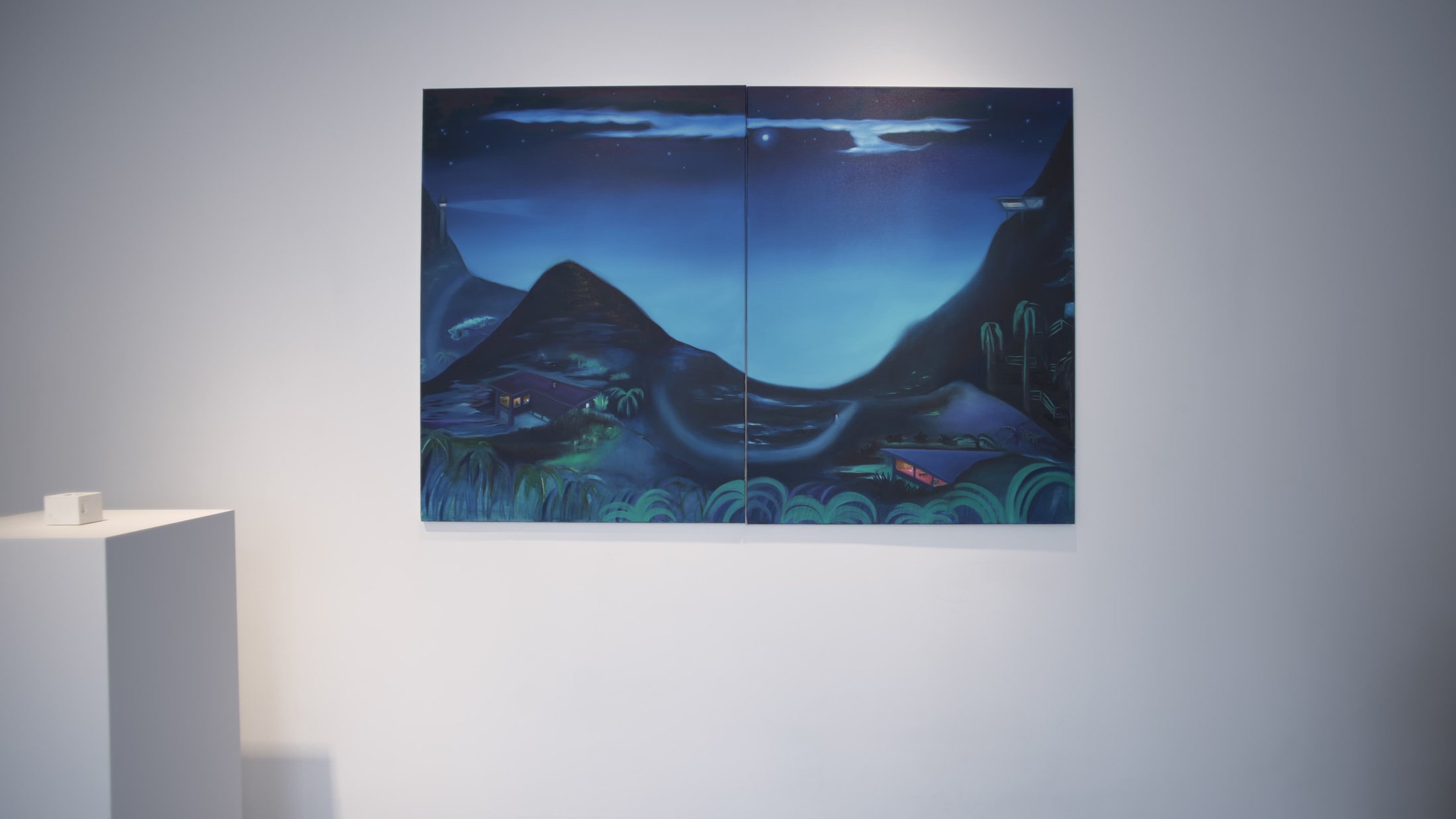 A large blue night landscape of hills and water above a white plinth.