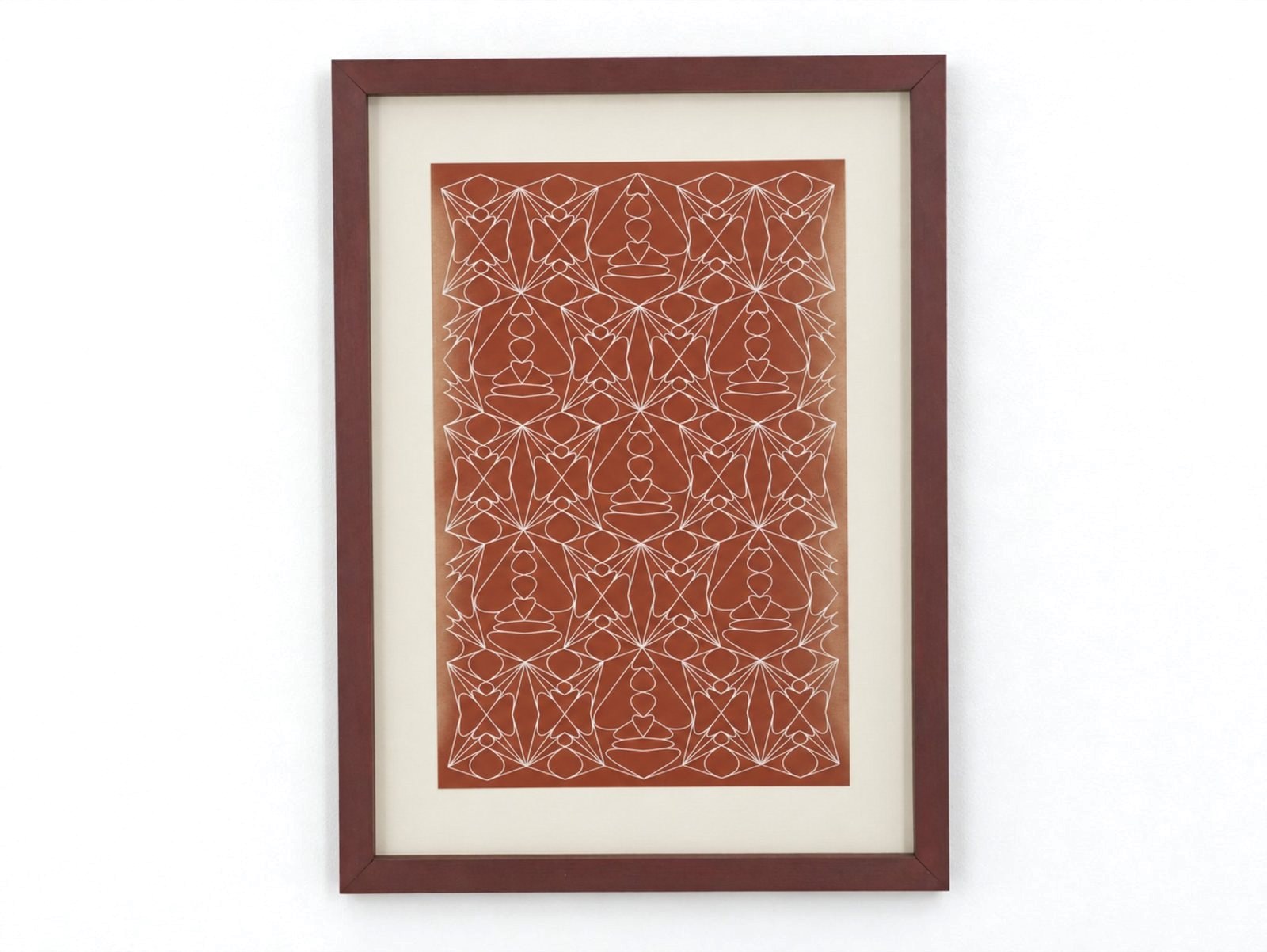 A symmetrical white line pattern printed on red, in a red frame.