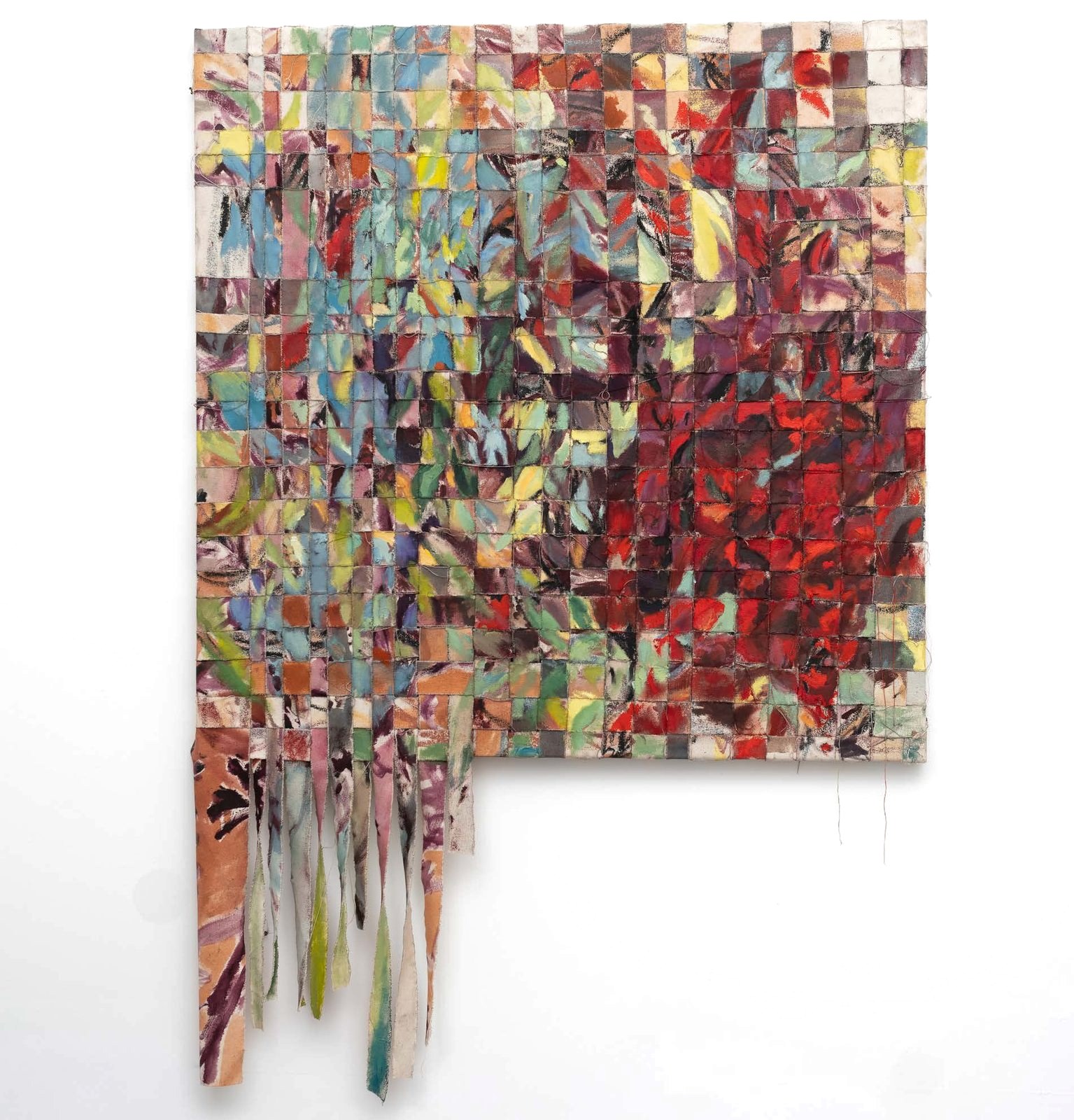 Strips of painted canvas woven into a dense patchwork of reds, greens and blues, with loose ends hanging below.