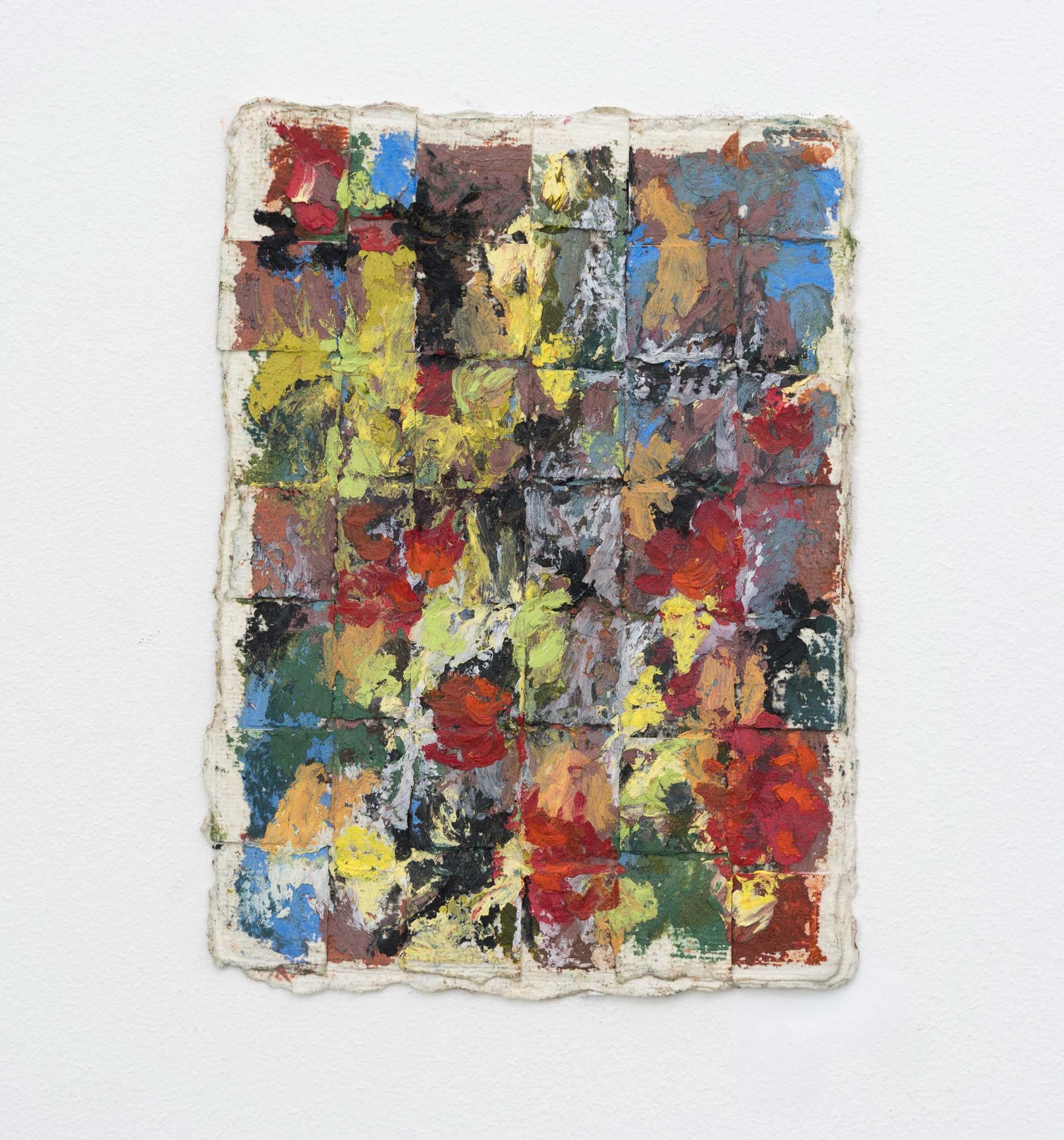 A small woven paper work with red, green, blue and yellow marks.