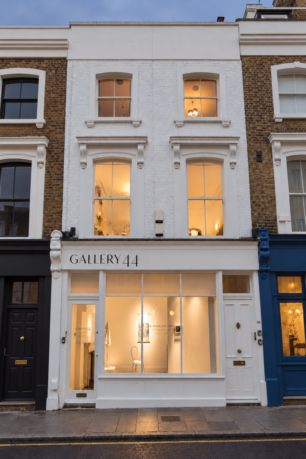 Gallery 44 at dusk: the white townhouse at 44 Chalcot Road, with warmly lit windows and the gallery entrance on the right.