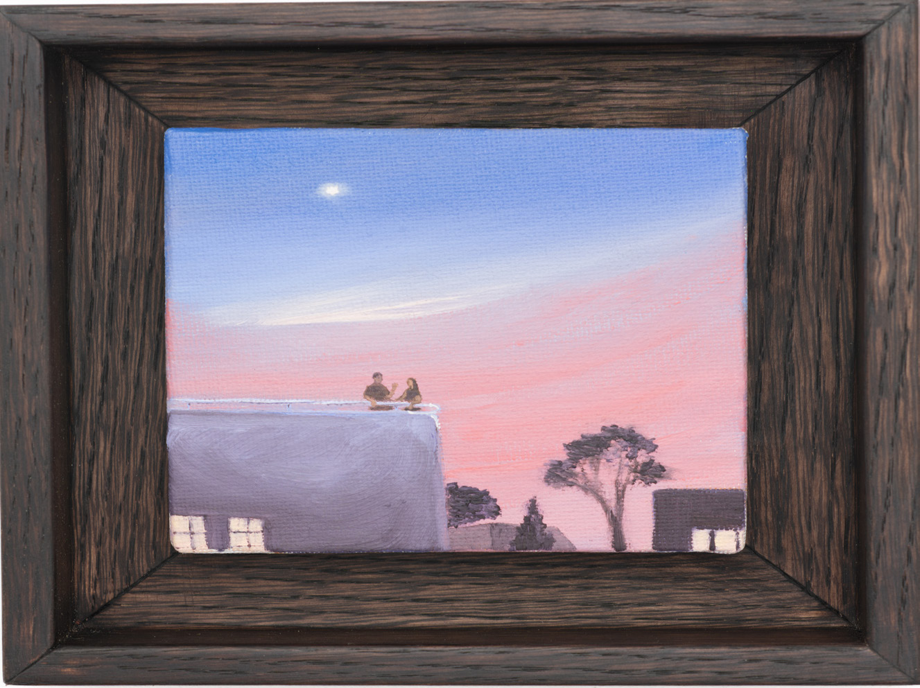 A pale rooftop beneath a pink evening sky, shown in a dark wooden frame.