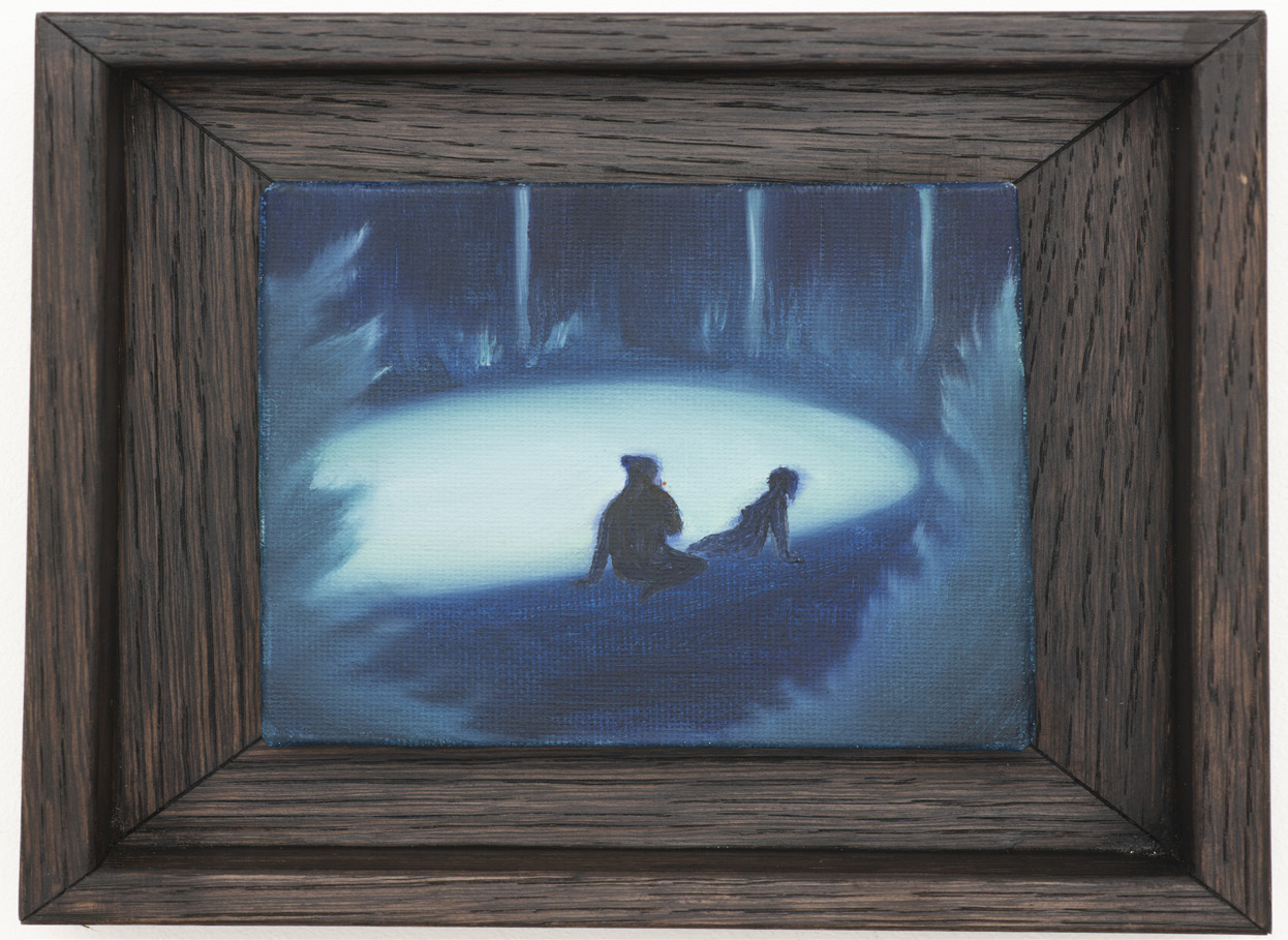 Two figures in a blue woodland clearing, shown in a dark wooden frame.