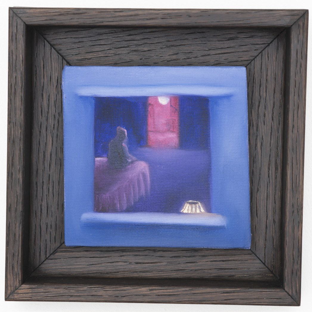 A seated figure glimpsed through a blue opening, shown in a dark wooden frame.