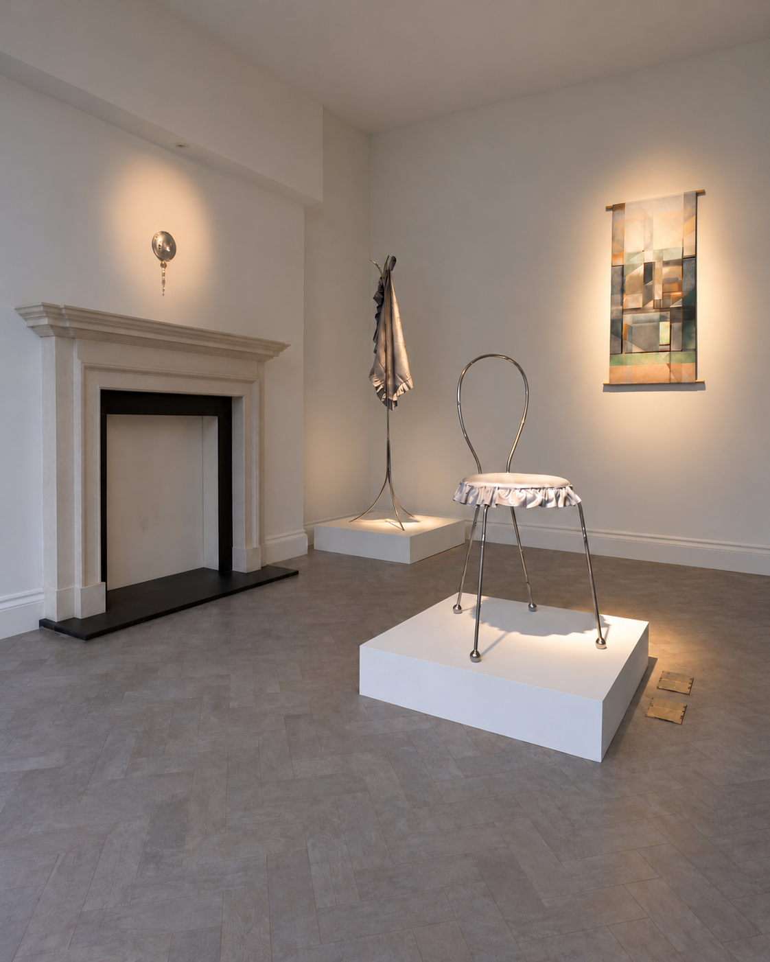 The front room in warm light: Marisa Müsing’s steel chair and coat rack on white plinths, a hand mirror above the fireplace, and Hayfa Algwaiz’s painting on the wall.